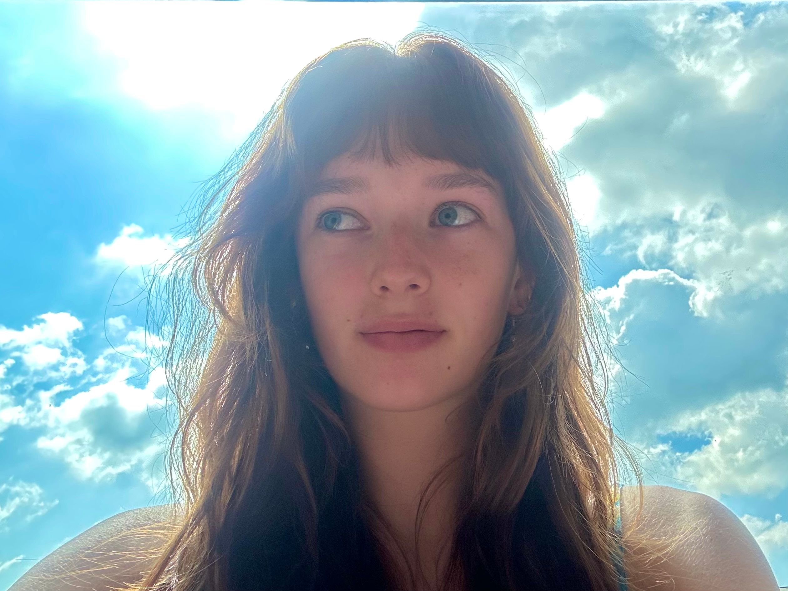 Self-portrait of Faye Ruby against a bright blue sky